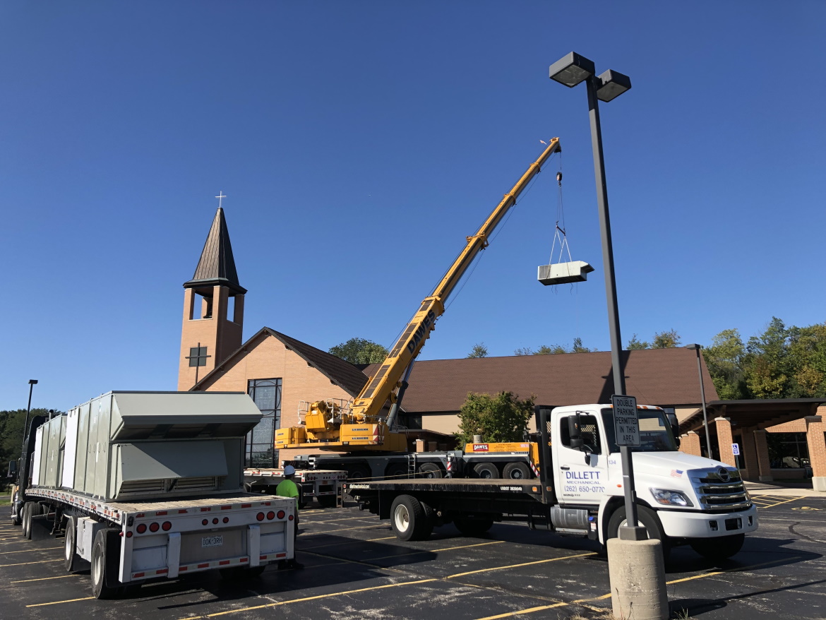 Dillett Mechanical lifting an HVAC unit